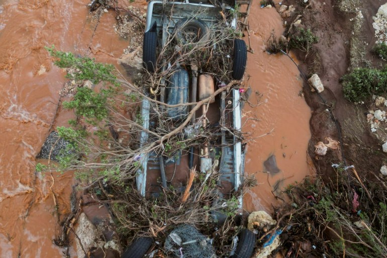 Aerial view of a damaged car and flood water on a road as a powerful storm and heavy rainfall hit Shahhat city, Libya, September 11, 2023. REUTERS/Ali Al-Saadi. NO RESALES. NO ARCHIVES