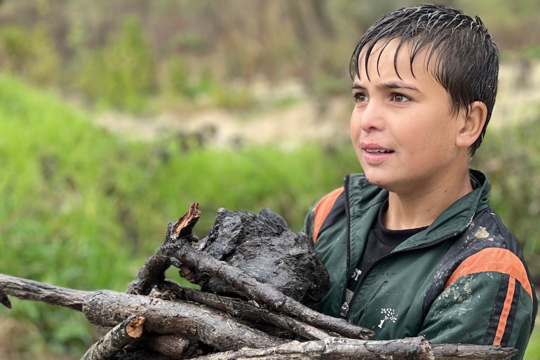 الأطفال يجمعون الحطب بين الجبال(الجزيرة نت)