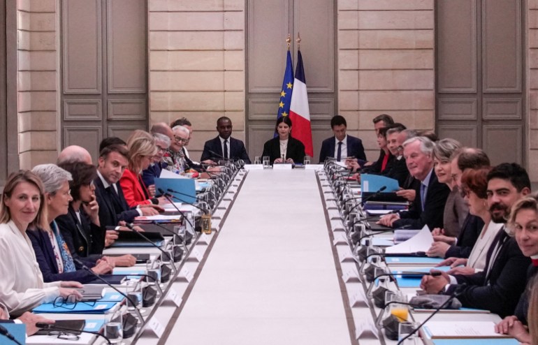 French President Emmanuel Macron (L) and French Prime Minister Michel Barnier (R) meet with members of the new government during the weekly cabinet meeting at the Elysee Palace, in Paris, on September 23, 2024. (Photo by Christophe Ena / POOL / AFP)