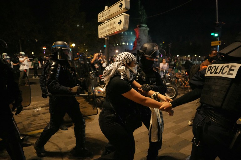 A protestor is detained by French Police during an unauthorized demonstration in support of Palestinians at Place de la Republique, in Paris, on October 12, 2023. - France on October 12, 2023 said it was banning all pro-Palestinian demonstrations after the attack on Israel by Hamas, on the grounds such protests threaten to public order. Interior Minister Gerald Darmanin said that the demonstrations "are likely to generate disturbances to public order" adding that organisers should face arrest. Fighting between Israel and Hamas has entered a sixth day following the assault on Israel by the Palestinian militant group on October 7, which has claimed thousands of lives on both sides. (Photo by Dimitar DILKOFF / AFP)