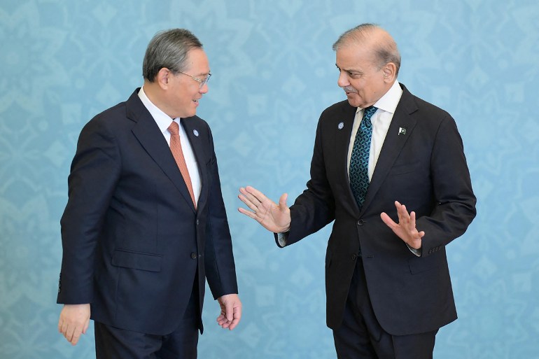 This handout photograph taken on October 16, 2024 and released by Pakistan's Press Information Department (PID) shows Pakistan's Prime Minister Shehbaz Sharif (R) speaking with China's Premier Li Qiang during the Shanghai Cooperation Organisation (SCO) summit, in Islamabad. - The SCO comprises China, India, Russia, Pakistan, Iran, Kazakhstan, Kyrgyzstan, Tajikistan, Uzbekistan and Belarus -- with 16 more countries affiliated as observers or "dialogue partners". (Photo by Pakistan's Press Information Department (PID) / AFP) / RESTRICTED TO EDITORIAL USE - MANDATORY CREDIT "AFP PHOTO/PAKISTAN'S PRESS INFORMATION DEPARTMENT (PID)" - NO MARKETING NO ADVERTISING CAMPAIGNS - DISTRIBUTED AS A SERVICE TO CLIENTS