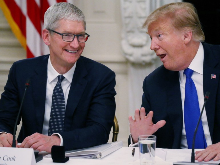 Apple CEO Tim Cook laughs with U.S. President Donald Trump as the news media leave the room after the two men spoke while participating in an American Workforce Policy Advisory Board meeting in the White House State Dining Room in Washington, U.S., March 6, 2019. REUTERS/Leah Millis