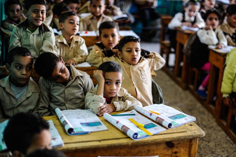 GIZA, EGYPT - OCTOBER 30: Egyptian students are seen during a lesson at the class of a primary school, where nearly 2 thousand students get education, in Baragil neighborhood of Giza, Egypt on October 30, 2014. Head master of the school complains about the crowded classroom sizes, reaching up to 70, lack of the desks and other impossibilities. Formal education, at every level, is provided freely at state schools in Egypt. Downswing due to the ongoing 4-year unrest, Egypt tries to overcome many difficulties and uncertainties. (Photo by Mohamed Hossam/Anadolu Agency/Getty Images)